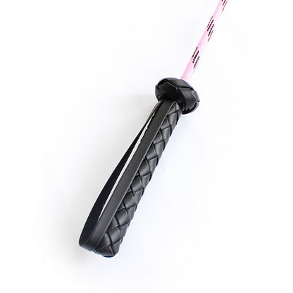 Second close-up view of pink feather riding crop handle and shaft connection