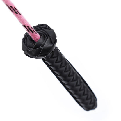 Close-up of faux leather handle on pink feather riding crop