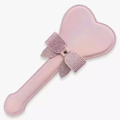 Pink iridescent heart-shaped spanking paddle full view with bow and rhinestone detail