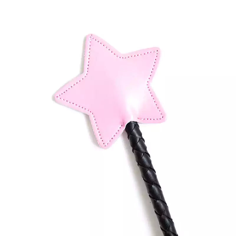 Close-up of star-shaped faux leather tip on pink riding crop