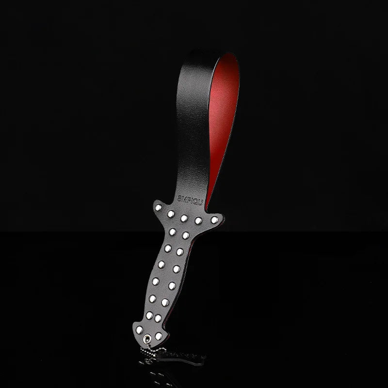 Punk studded leather slapper in dark setting