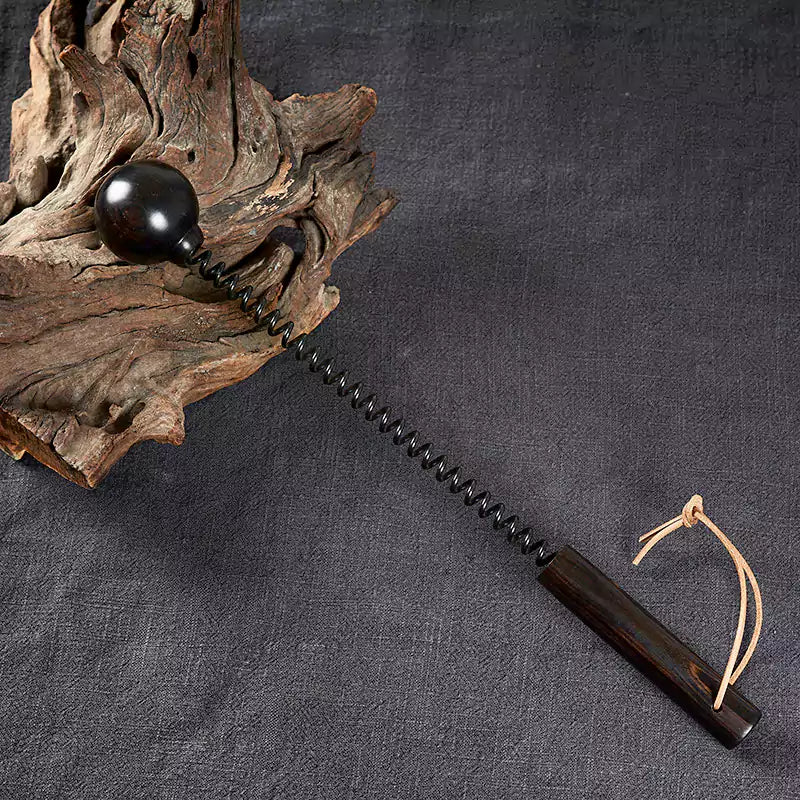 Purple ebony spring spanking mallet in a styled scene with natural wood texture visible