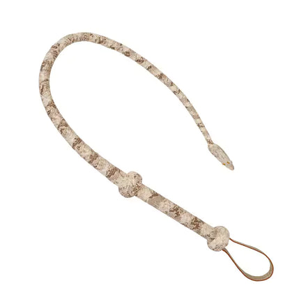 angled display of handcrafted leather whip showing raised knot handle and wrist strap