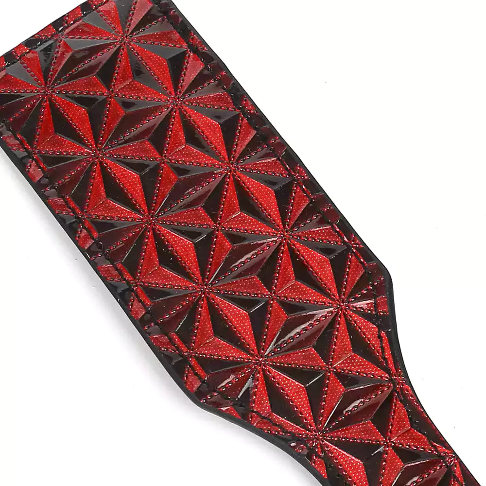 Full view of red diamond-textured paddle face on faux leather paddle