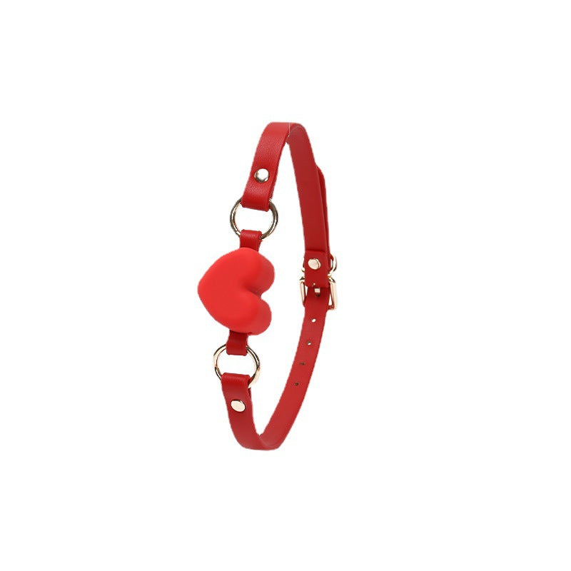 Side view of the red heart-shaped silicone ball gag with wide strap