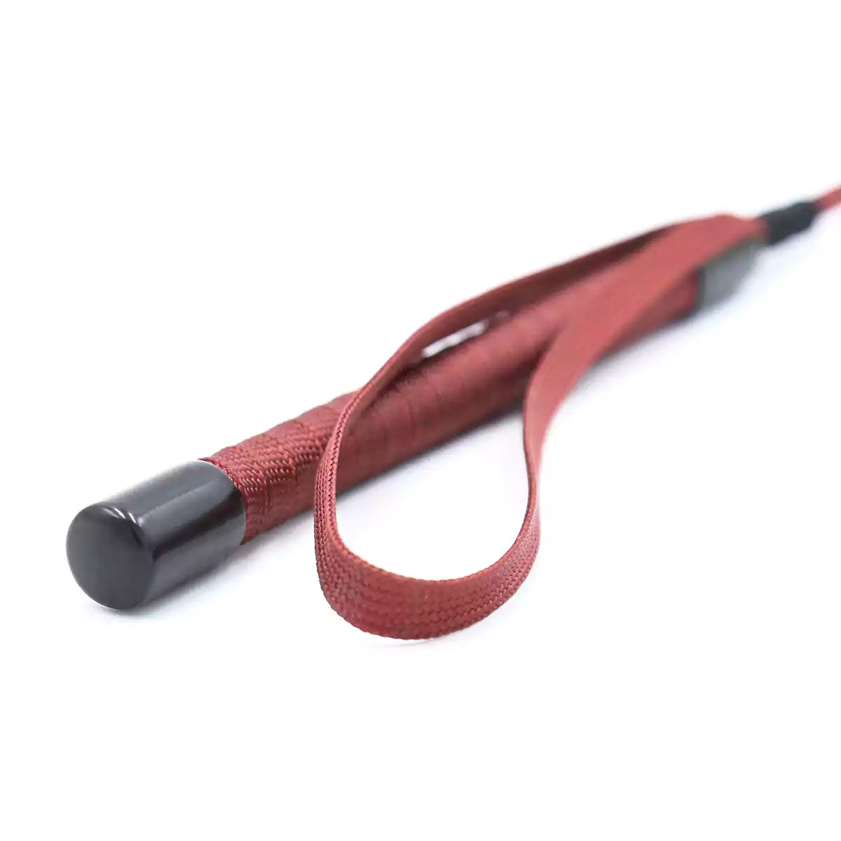 Close-up of handle on red long BDSM riding crop