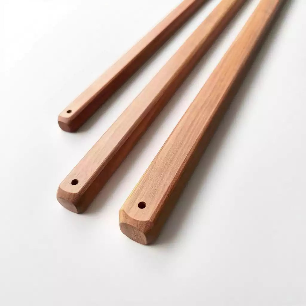 Close-up of red sandalwood square discipline rod showing edge profile