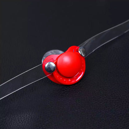 Close-up detail of the silicone pacifier restraint gag and clear PVC strap
