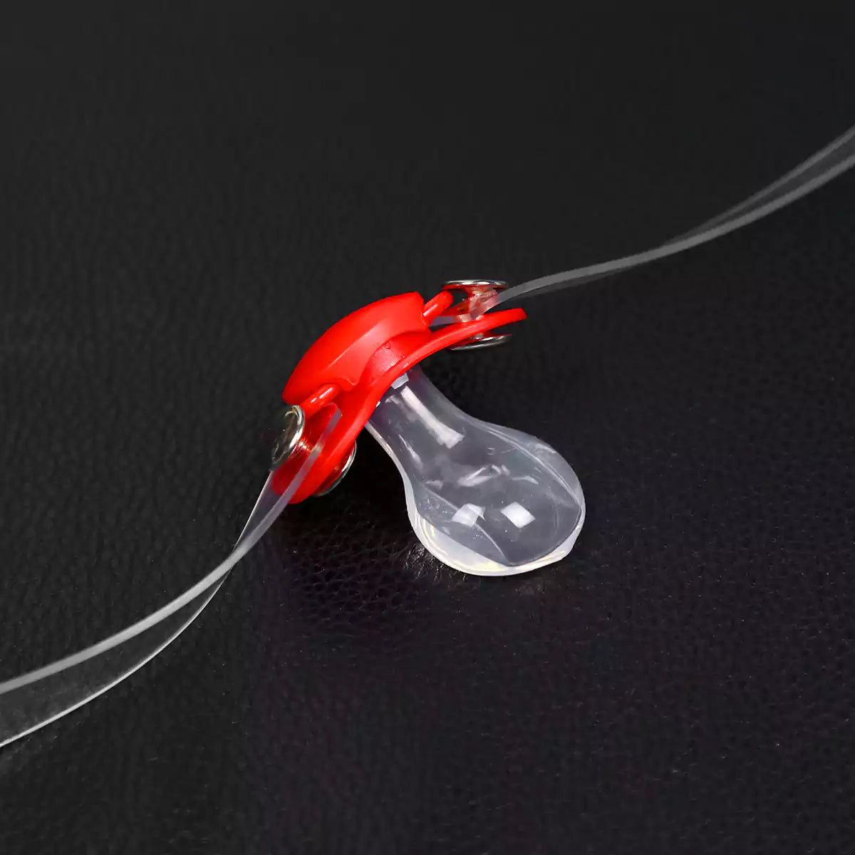 Detailed view of the silicone pacifier restraint gag construction and transparent strap