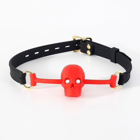 Red silicone BDSM ball gag with vented skull mouthpiece displayed on a clean white background
