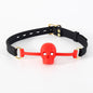 Red silicone BDSM ball gag with vented skull mouthpiece displayed on a clean white background