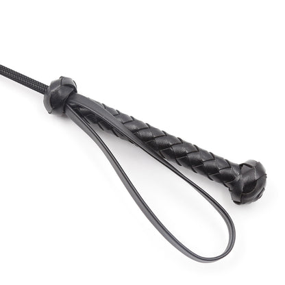Close-up detail of the braided black handle on the stitched-tip riding crop