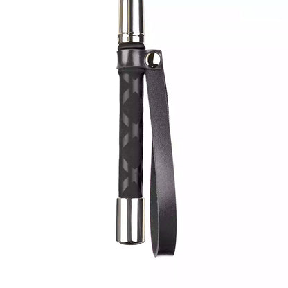 Close-up of metal accent handle on vintage black long-handle riding crop