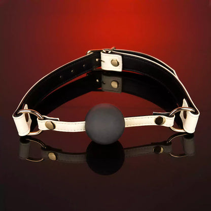 White leather ball gag displayed in a styled product setting
